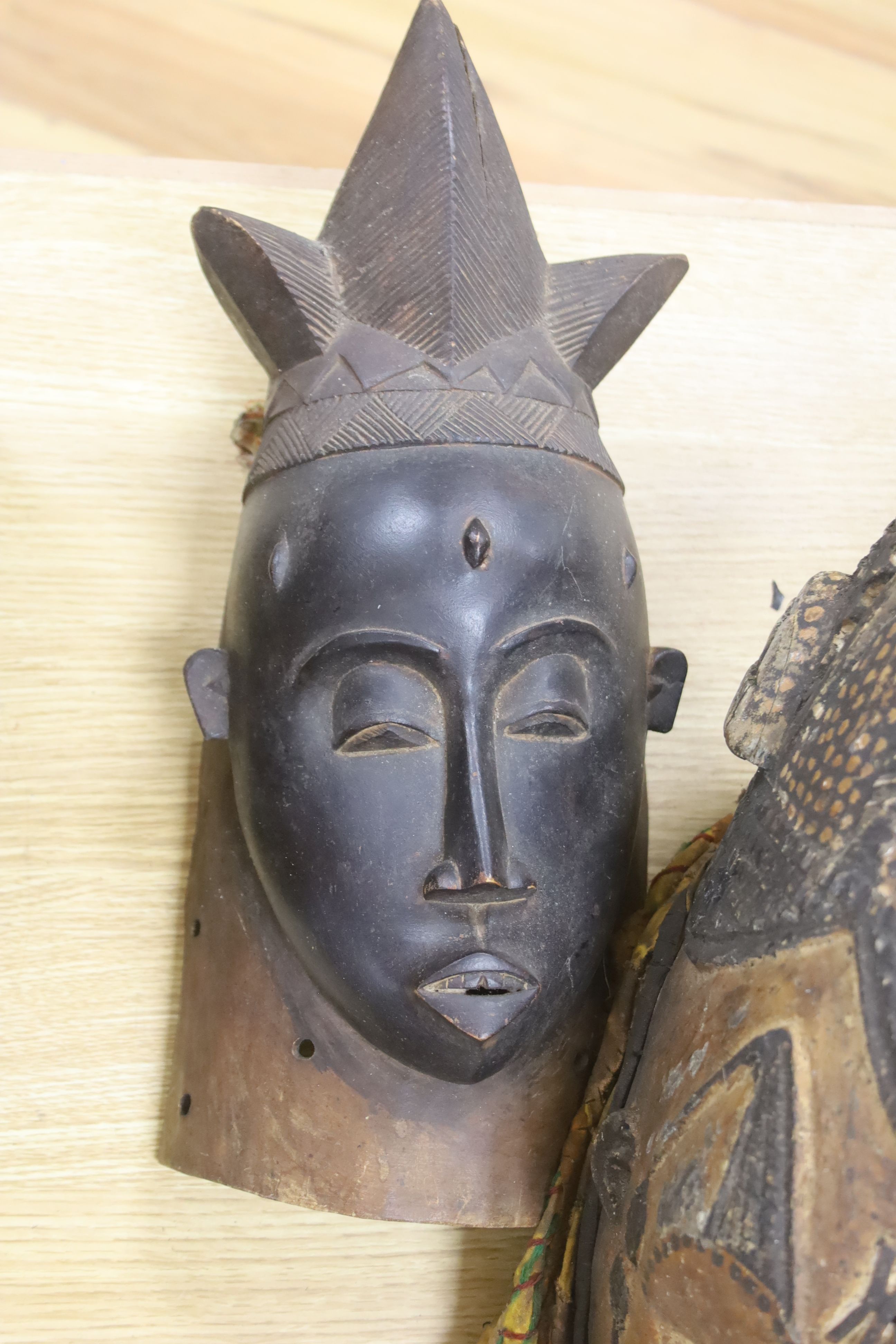 An African helmet mask, possibly Kaba, and two others